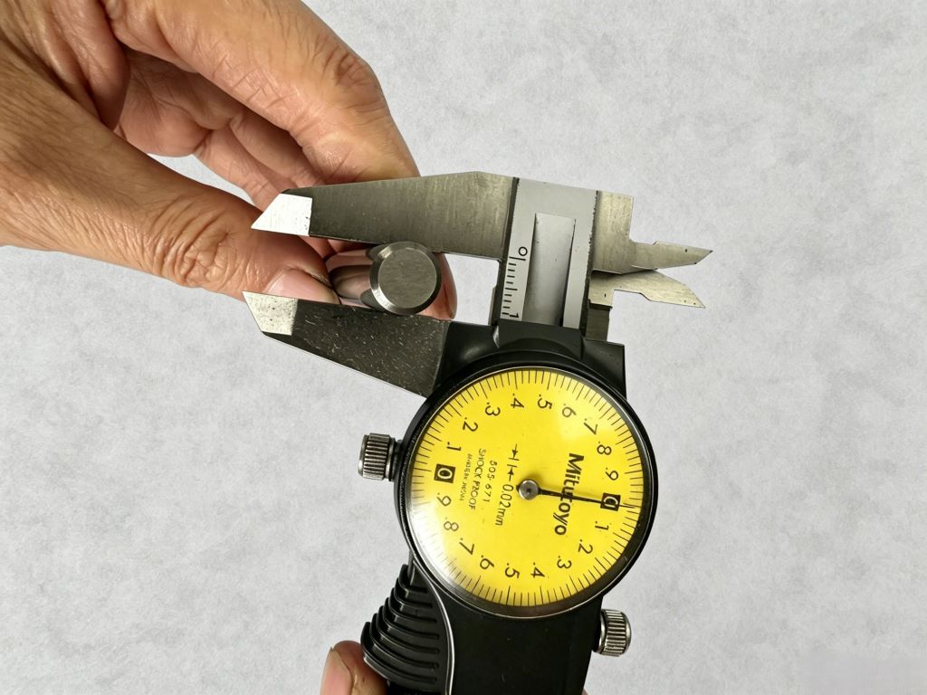 Zonclair quality inspector measuring a custom machined aluminum part with a digital caliper for DFM verification.