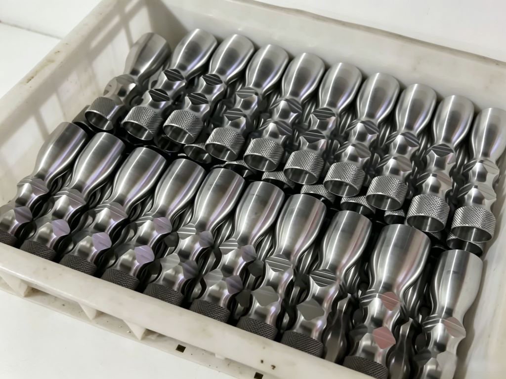 Batch production of high-precision CNC turned metal parts inside a manufacturing storage box at Zonclair factory.